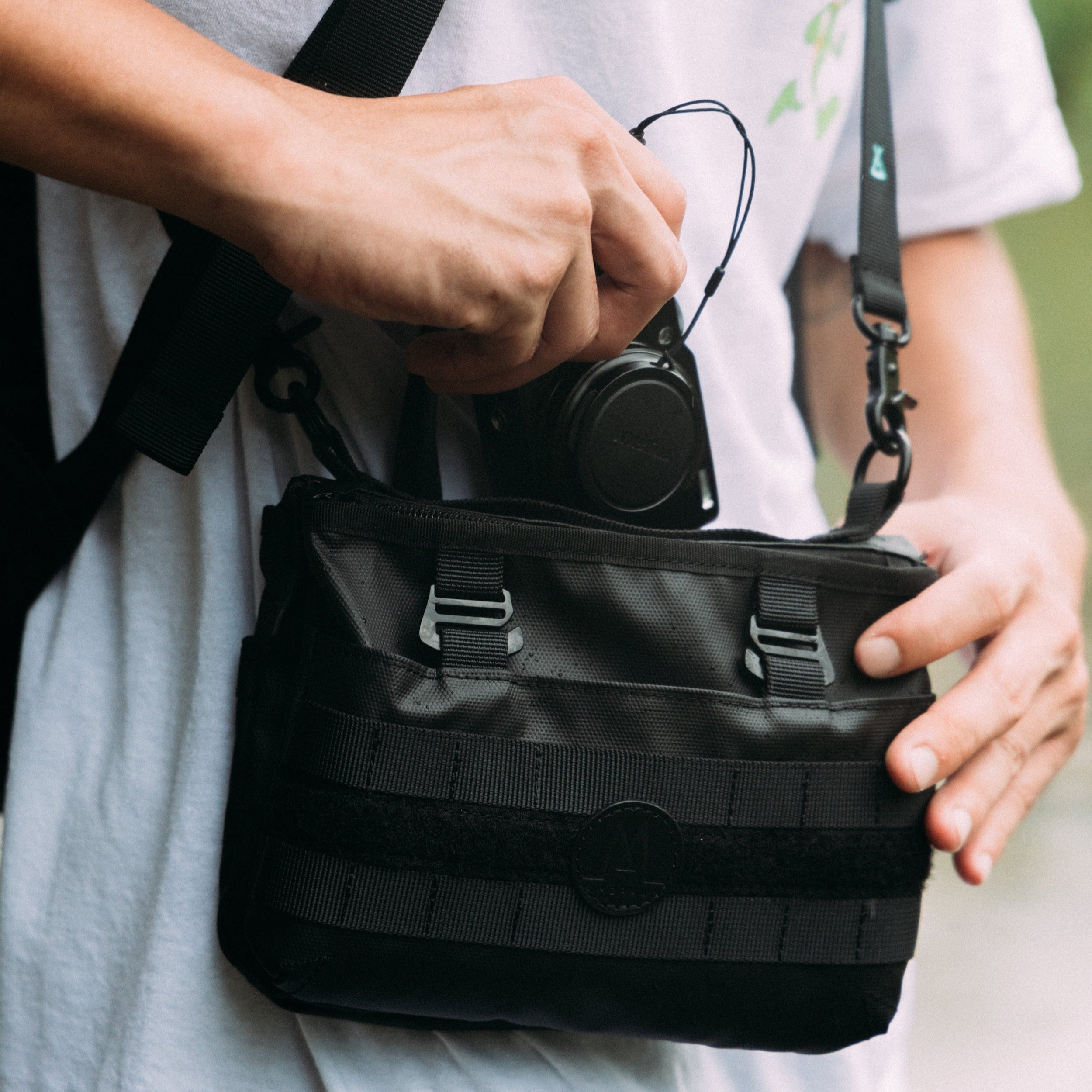 Moral NIGHTHAWKS MILITARY DUO MINI 軍事風側背包展示其大容量主袋設計,方便收納相機等隨身物品。包身採用黑色軍事風格,展現品牌細節與堅固質感。