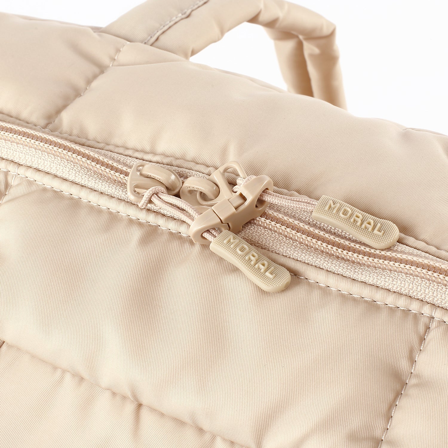 MORAL Chapel 方型單肩包(大)米白色拉鍊細節特寫,拉鍊頭印有品牌標誌。設計精緻,展現高度質感與實用性。