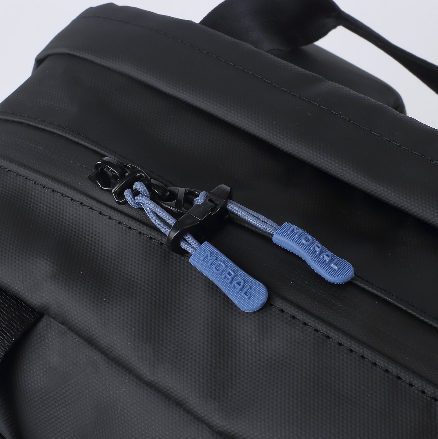 MORAL X LEANNE.LY BUDD GIZZA 背包 近距展示藍色拉鍊細節,配有品牌標誌的拉繩,結合實用性與設計感。