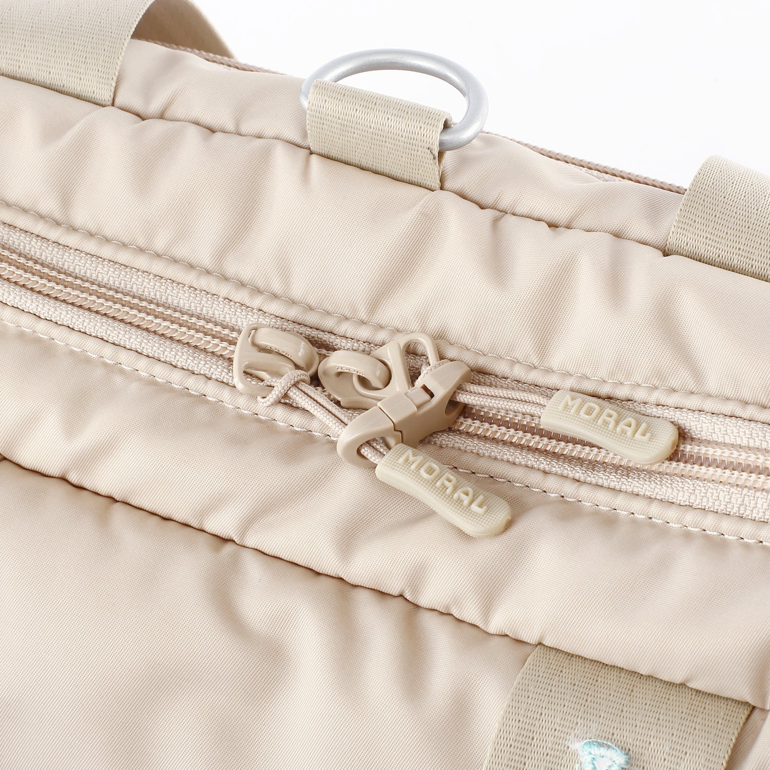 MORAL Chapel 托特背包米色款,細部展示品牌標誌拉鍊設計。雙拉鍊頭與金屬掛環,提升實用性與質感。