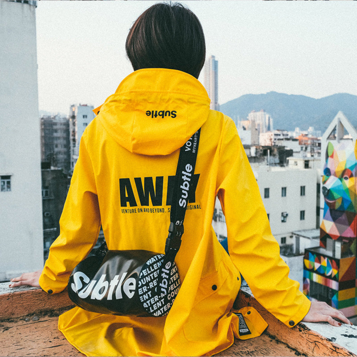 SUBTLE AWAY Raincoat 全天候防水防風風衣,背部絲印展現自由旅行風格。
