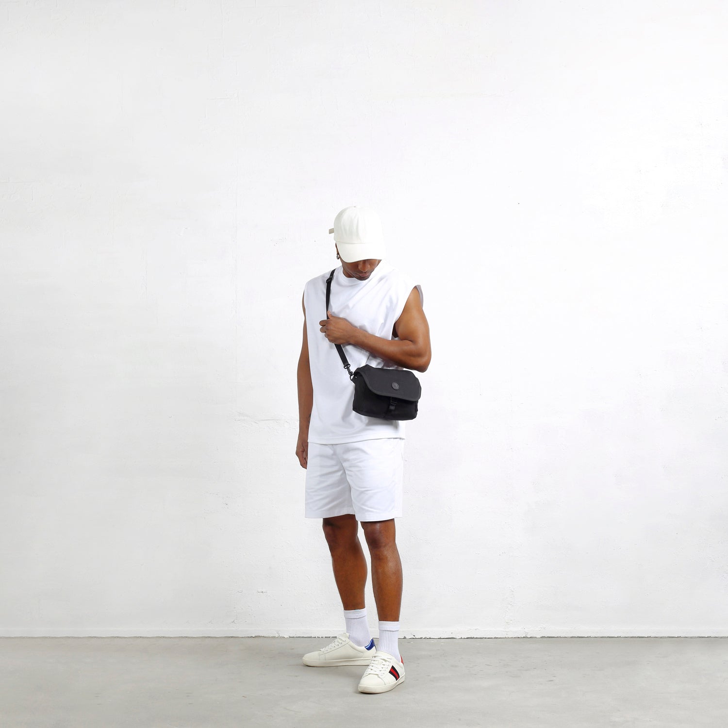 模特背著MORAL Northside Bostin郵差包(小) 詭密黑,展現休閒時尚穿搭。包款設計簡約,適合日常外出使用。