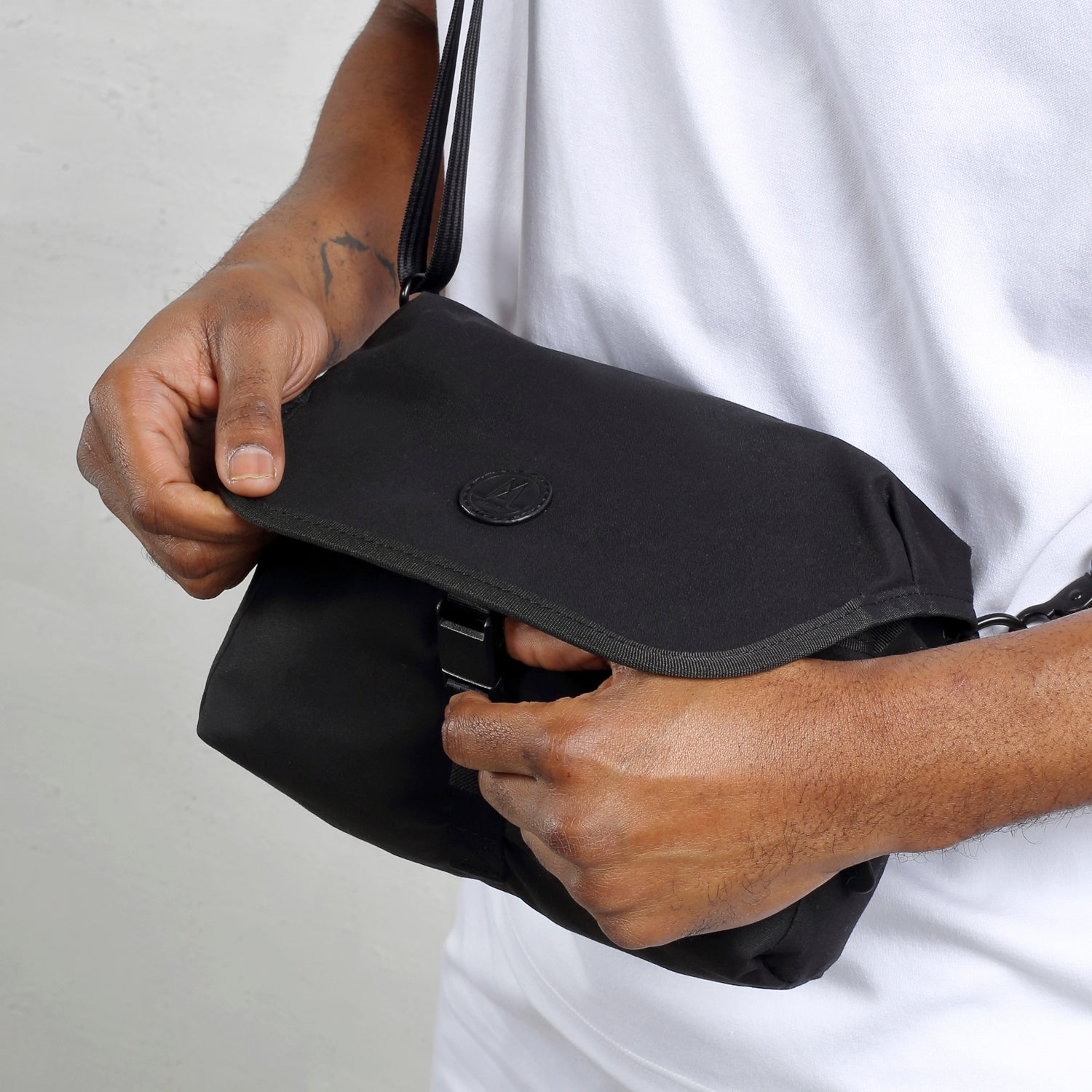 展示MORAL Northside Bostin郵差包(小)的磁扣設計。此包款細節精緻,兼具時尚與實用收納功能。