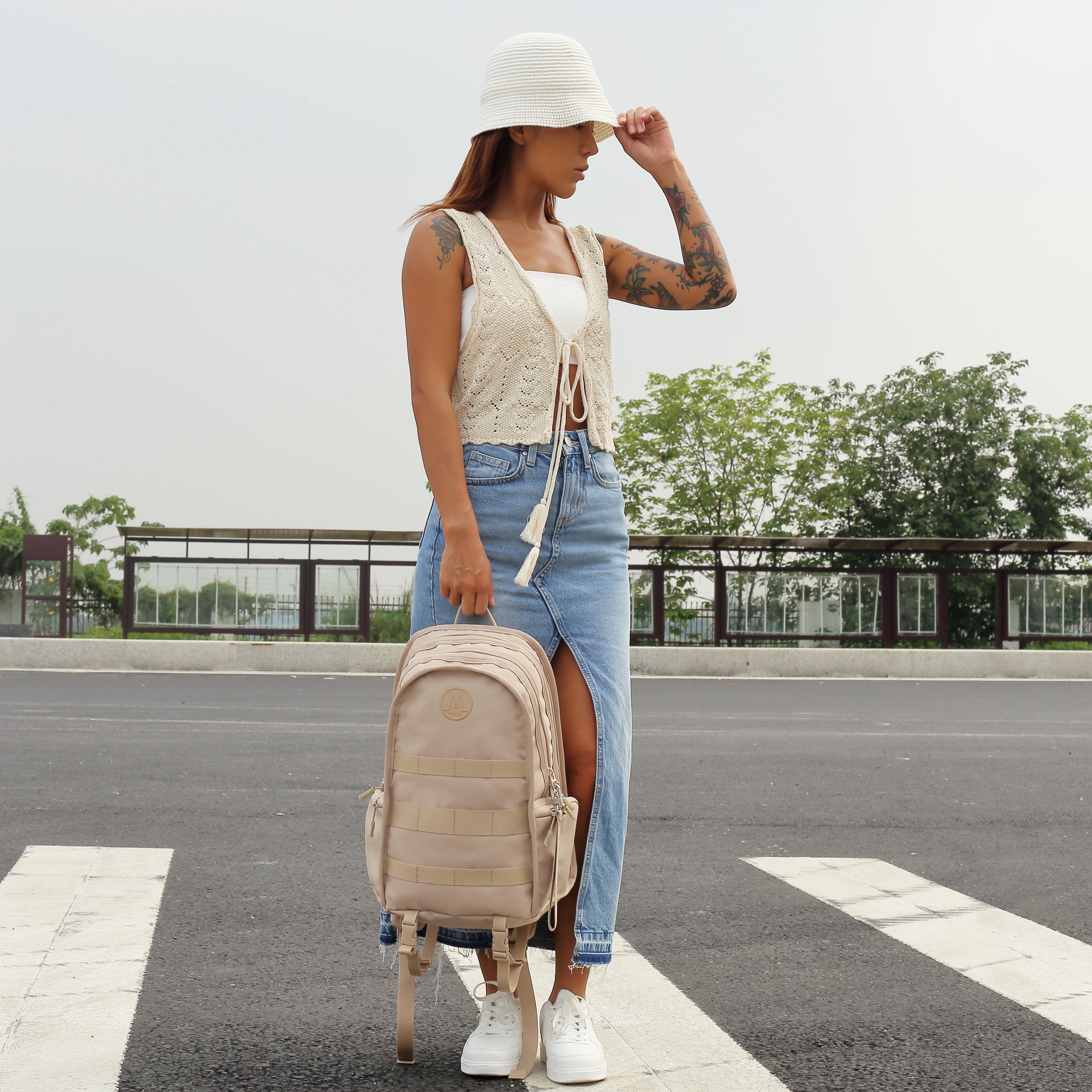 MORAL Napier Poser 運動背包中碼杏白色,包身有品牌標誌及多條織帶設計。外型俐落,適合日常與戶外使用。